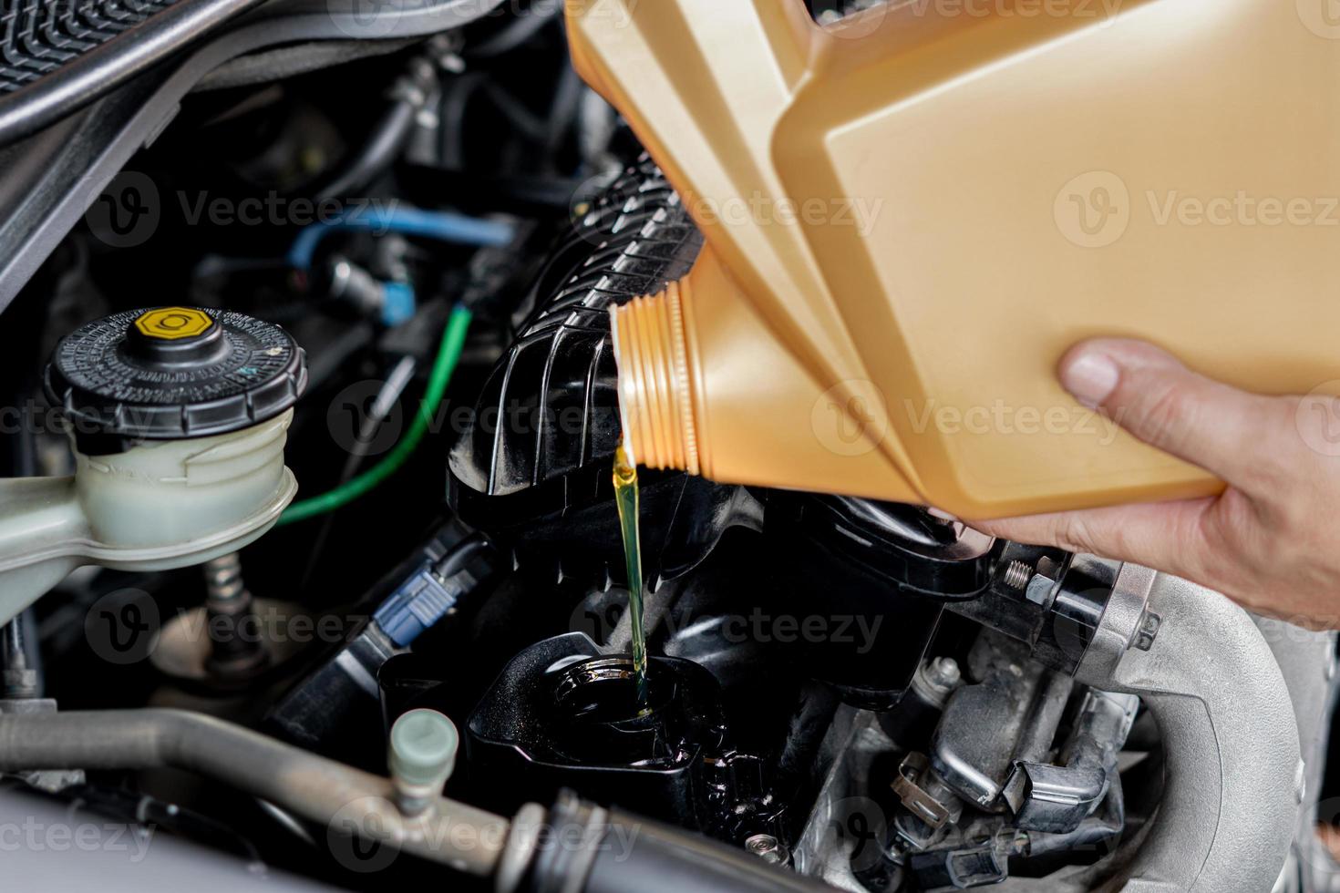 A man Pouring oil to car engine. Fresh oil poured during an oil change