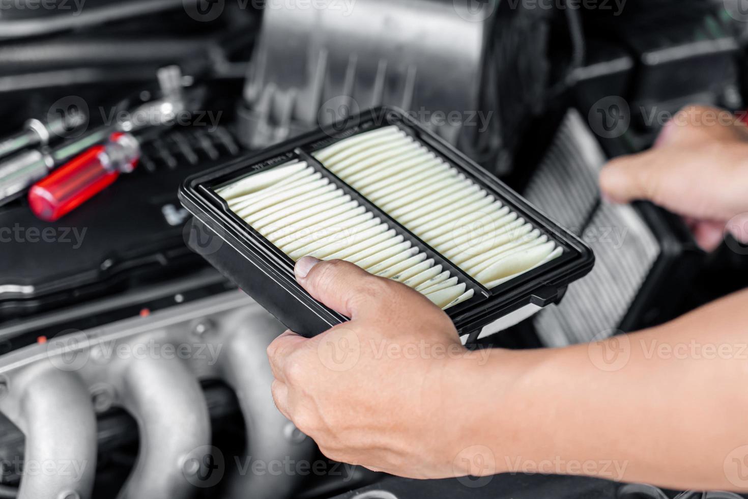 el hombre de servicio reemplaza el filtro de aire del motor viejo en comparación con el nuevo en la sala del motor, el concepto de camión de servicio doméstico foto