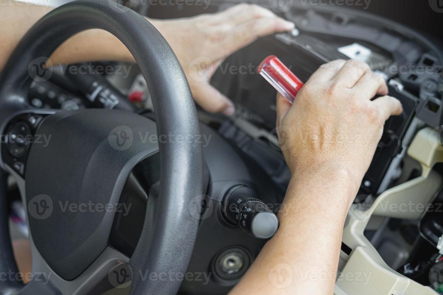 Close up hand Technician remove car speedometer with screw driver in side cabin check and Replace new parts to replace the broken in car service shop photo