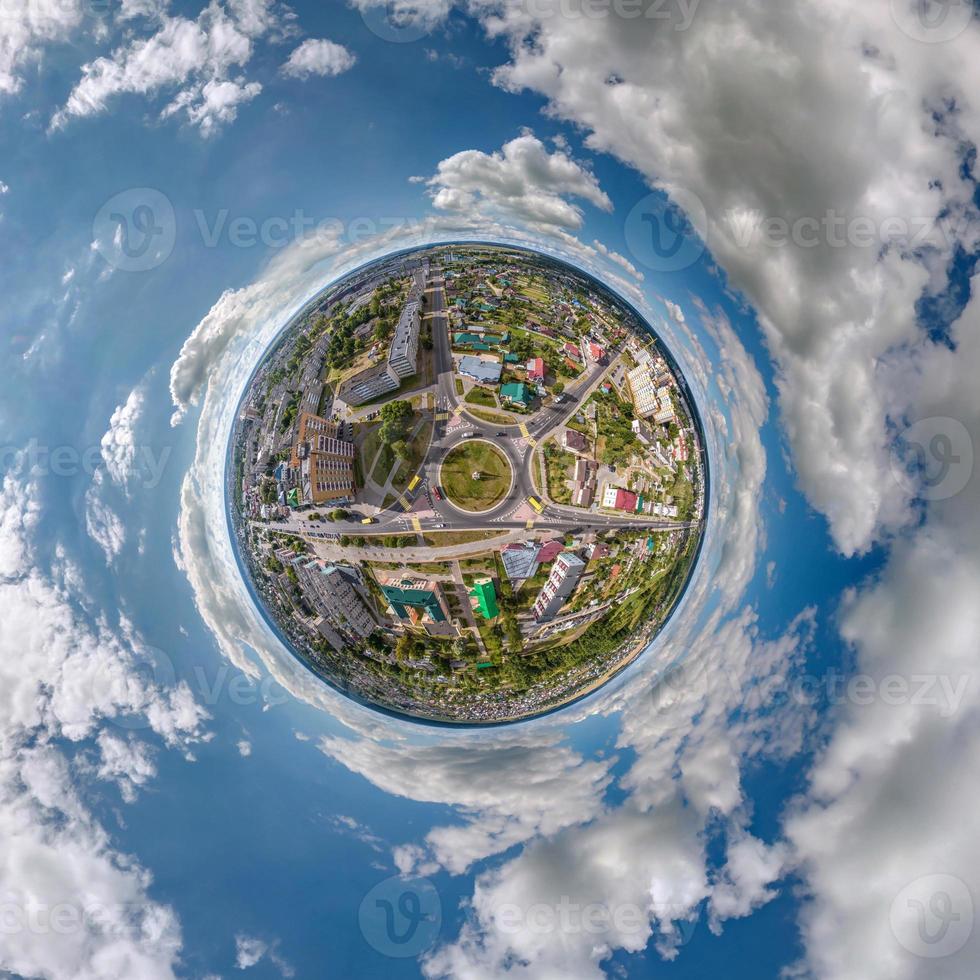 tiny planet in sky with clouds overlooking old town, urban development, historic buildings and crossroads. Transformation of spherical 360 panorama in abstract aerial view. photo