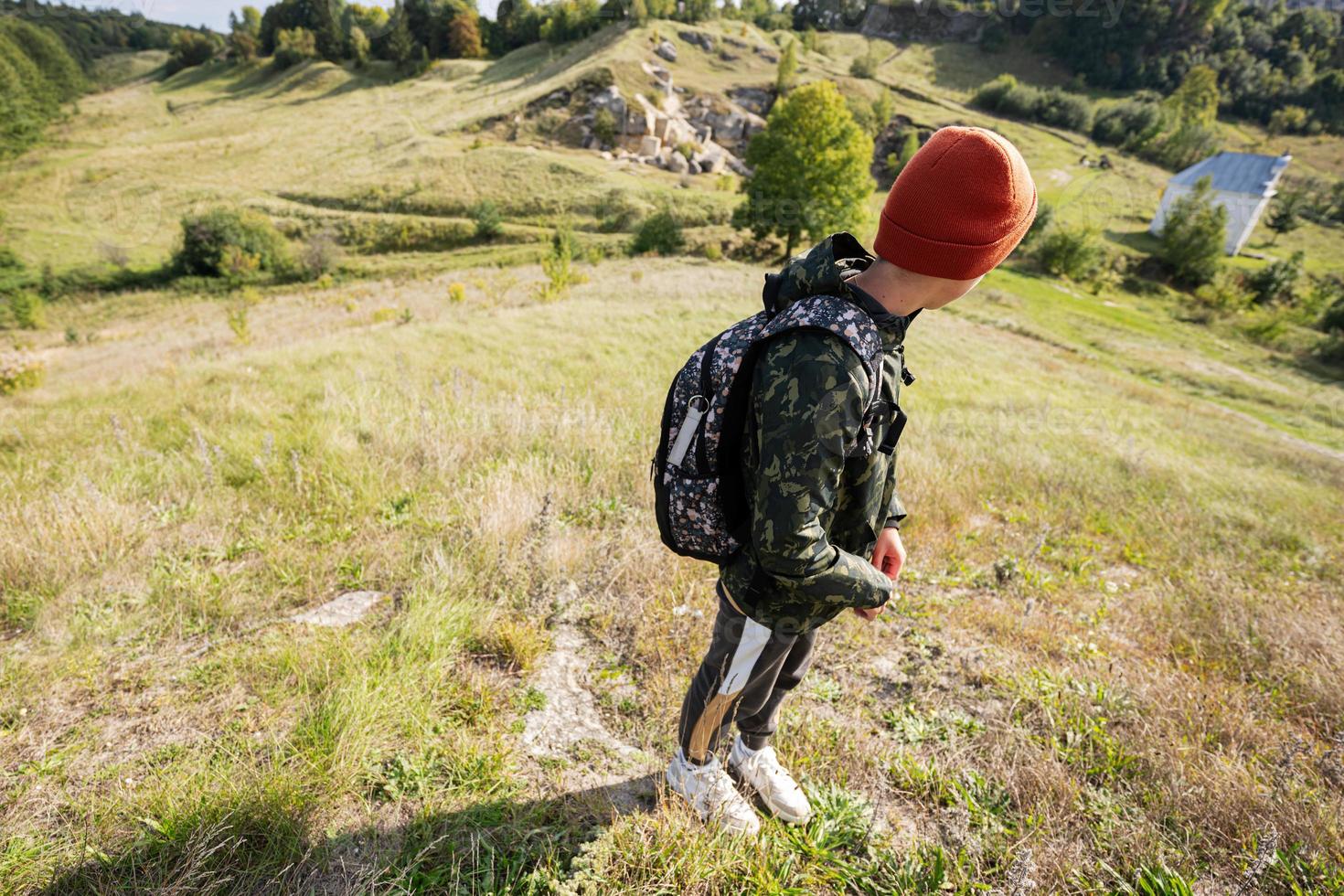 Activity on sunny autumn day, boy exploring nature. Kid wear orange hat and backpack hiking. photo