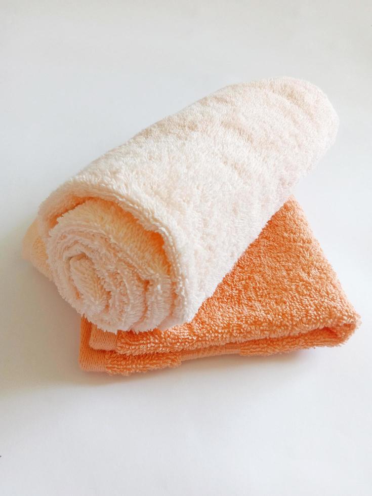 beige rolled towel and small orange towel photo