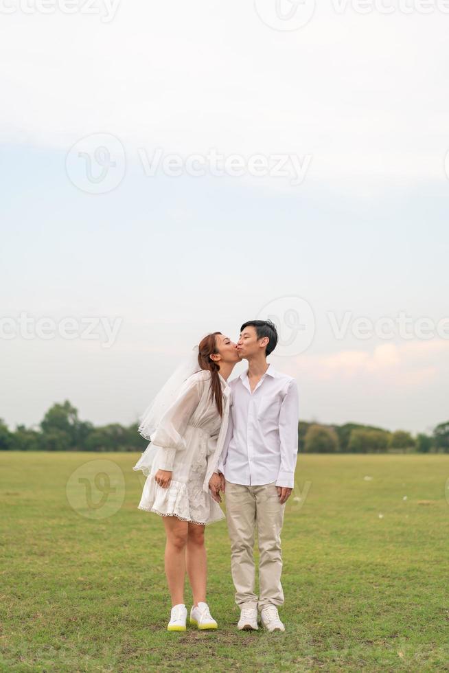 Happy young Asian couple in bride and groom clothing photo