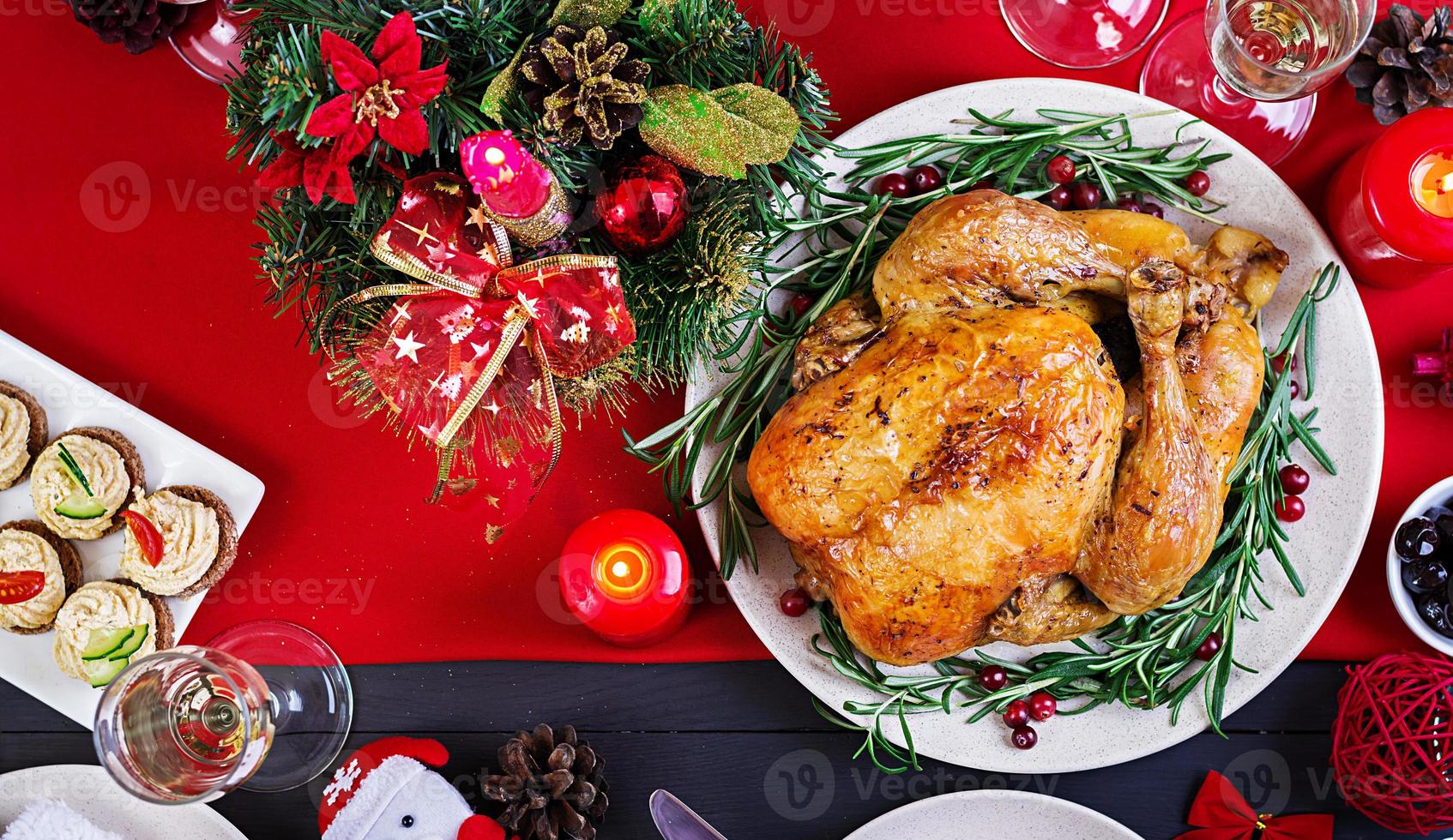 Baked turkey. Christmas dinner. The Christmas table is served with a turkey, decorated with bright tinsel and candles. Fried chicken, table.  Family dinner. Top view photo