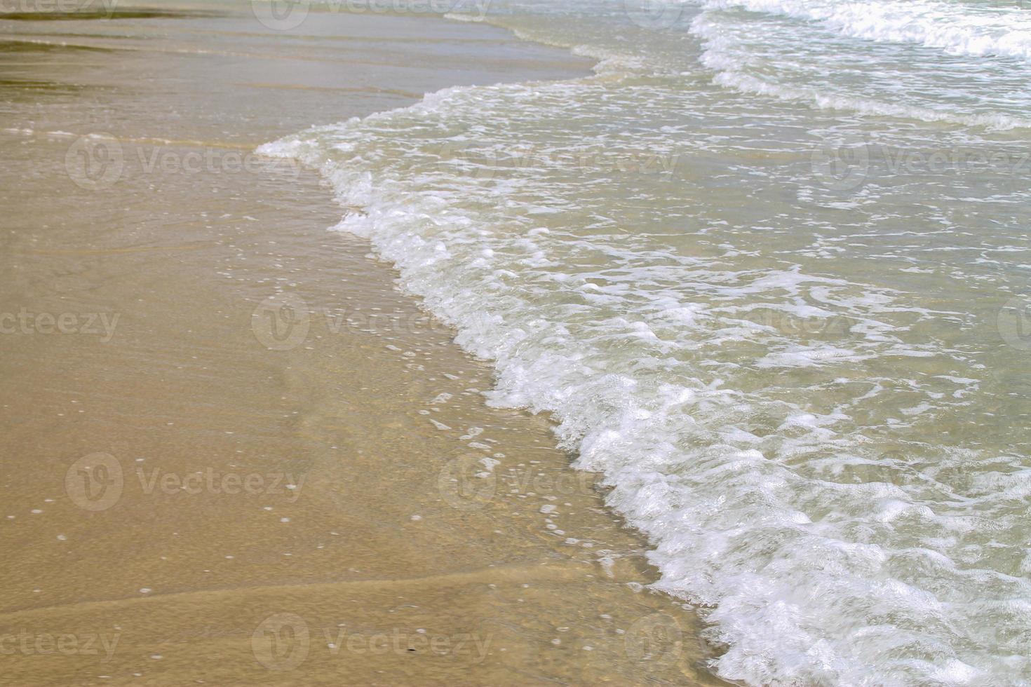suave ola azul del océano en la playa de arena. antecedentes. foto