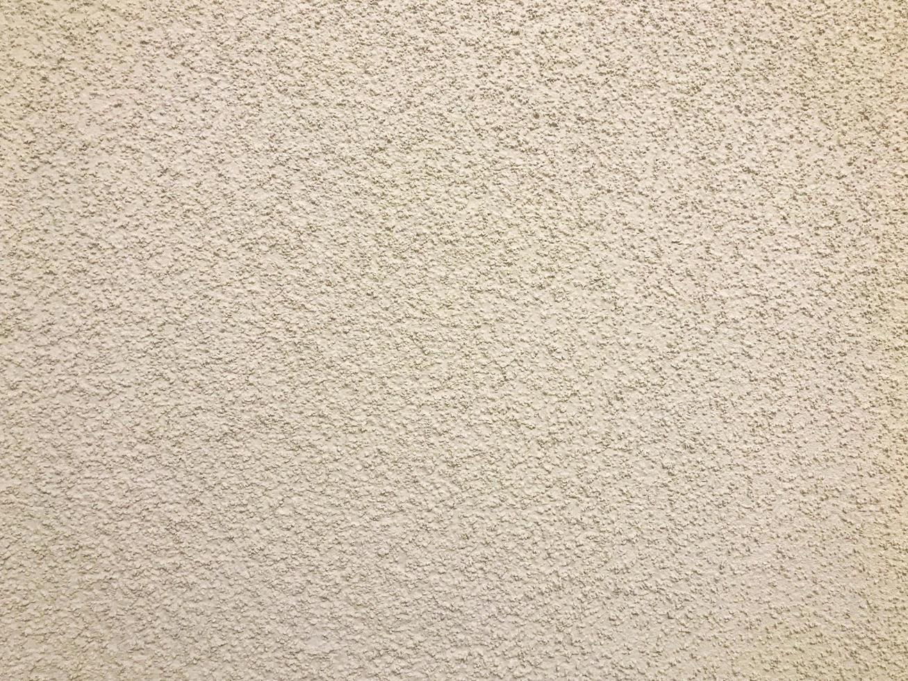 The texture of the rough wall of beige decorative plaster used for wall decoration of entrances. The background photo