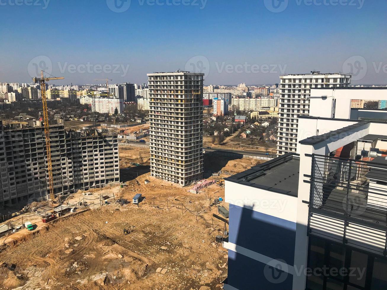 Building with the help of construction cranes of high reinforced concrete, panel, cast-frame, frame-block houses, buildings, skyscrapers, new buildings on the background of sandy land photo