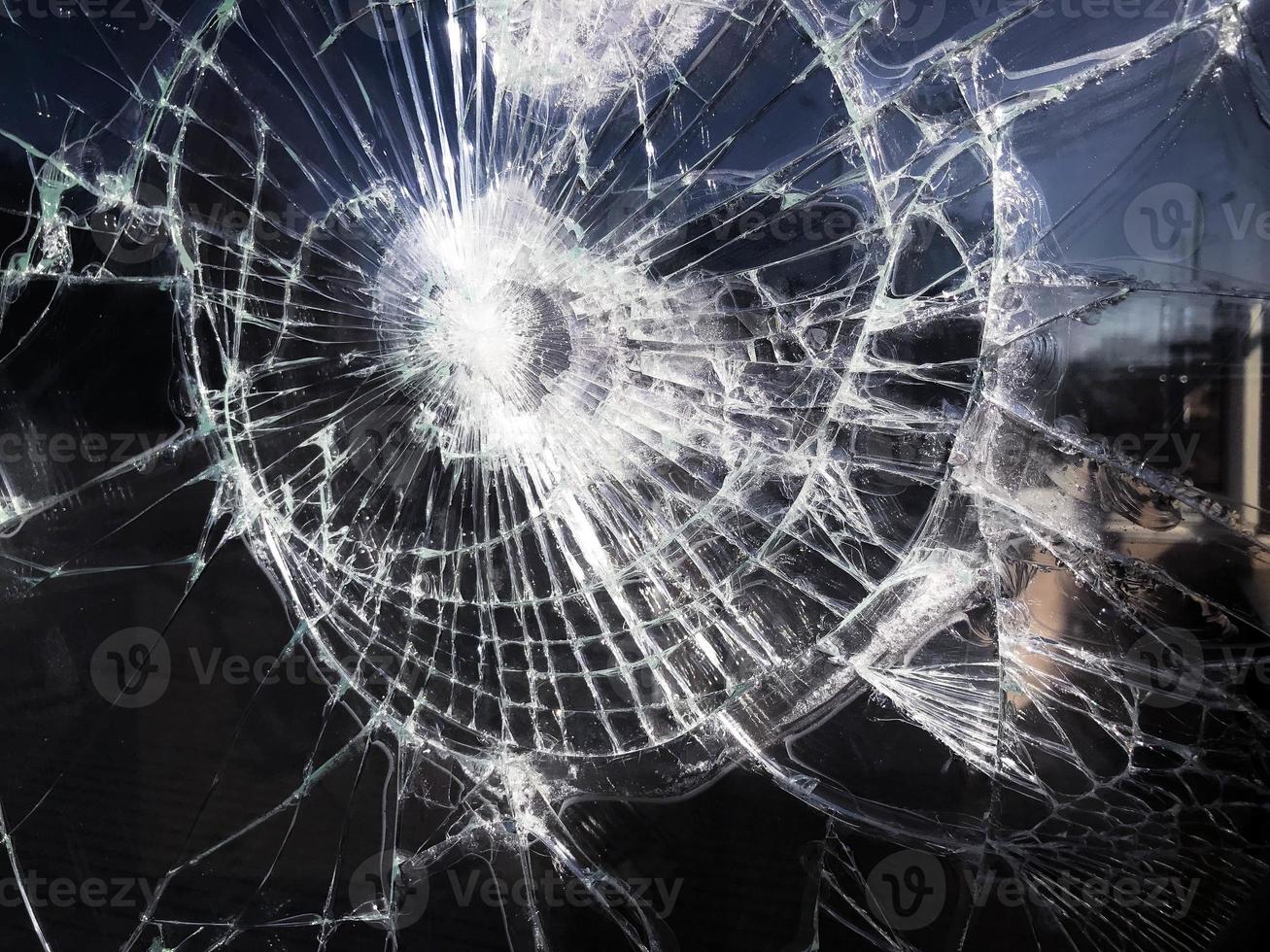 The texture of the broken cracked thick fragile broken sharp glass, triplex with shiny small fragments. The background photo