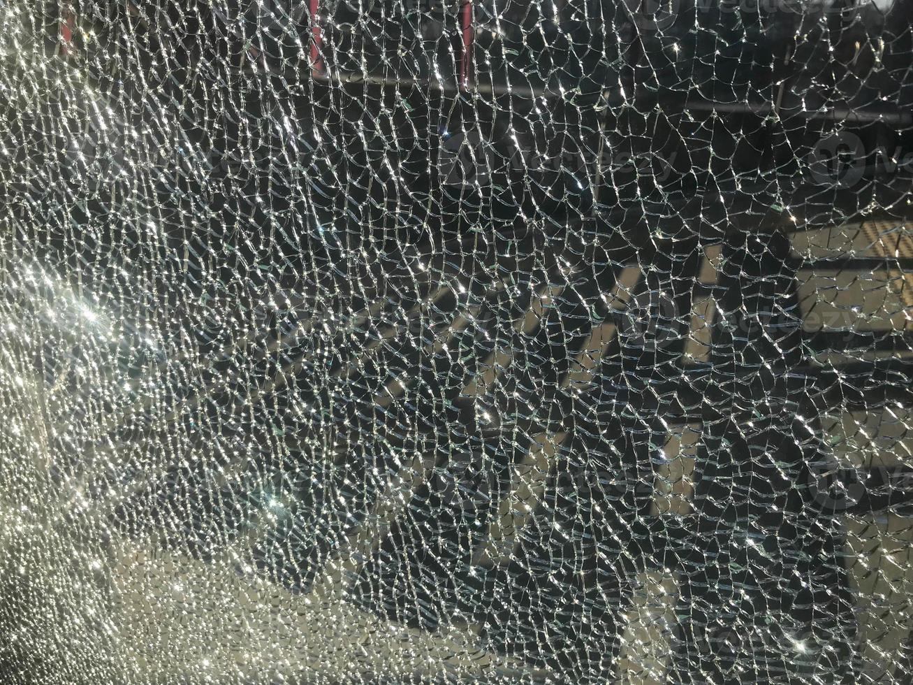 The texture of the broken cracked thick fragile broken sharp glass, triplex with shiny small fragments. The background photo
