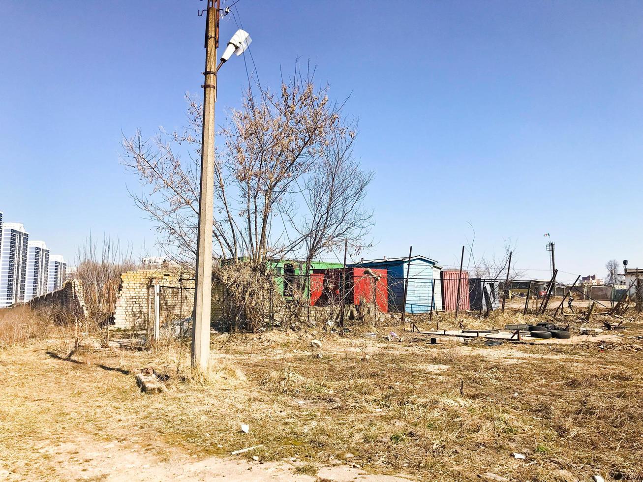 Trash dirty household and construction lies on the ground on the street against the background of garages in the city on the field. Concept environmental pollution, garbage, environmental problems photo