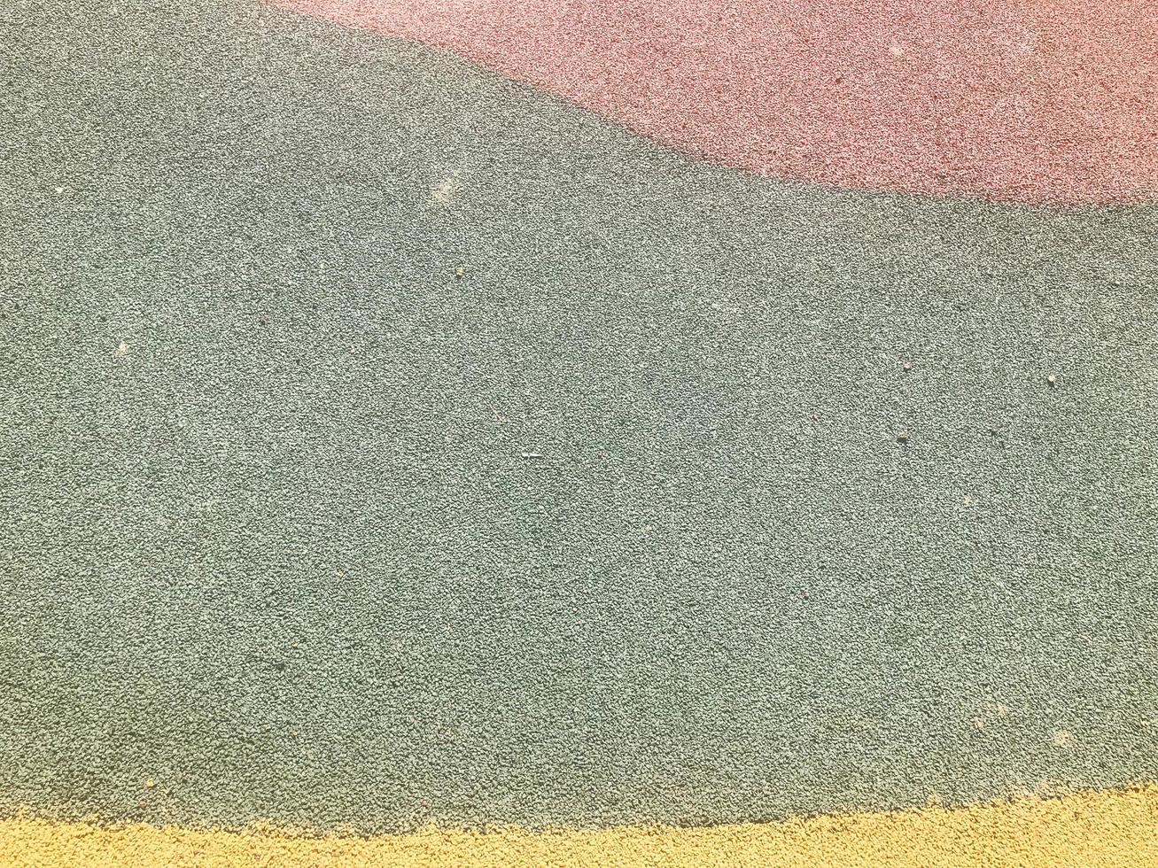 The texture is red green and yellow from soft protective rubber, rubber crumb for safety used for playgrounds, workout. The background photo