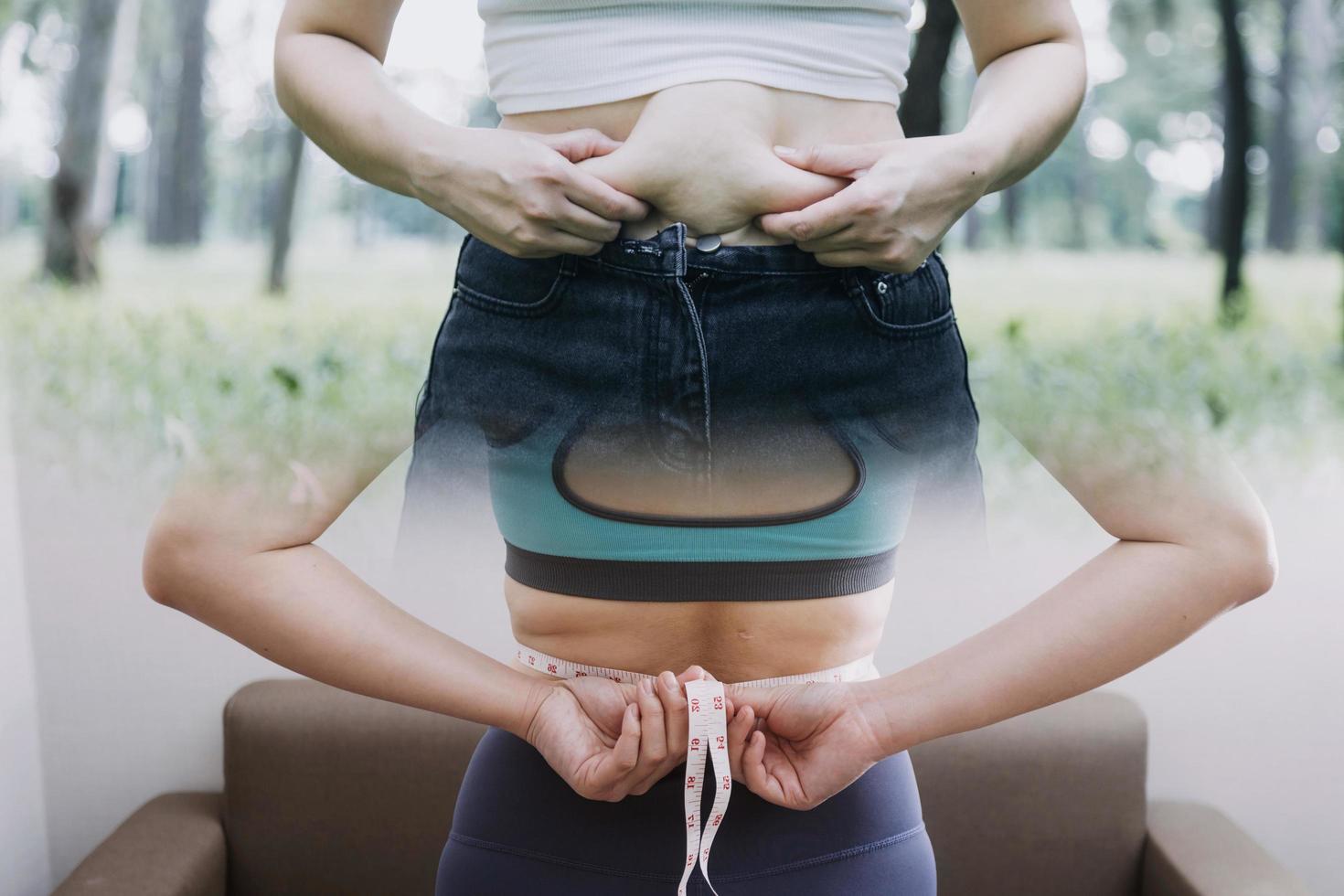 hermosa mujer gorda con cinta métrica usa su mano para exprimir el exceso de grasa que está aislado en un fondo blanco. ella quiere perder peso, el concepto de cirugía y descomponer grasa bajo el foto