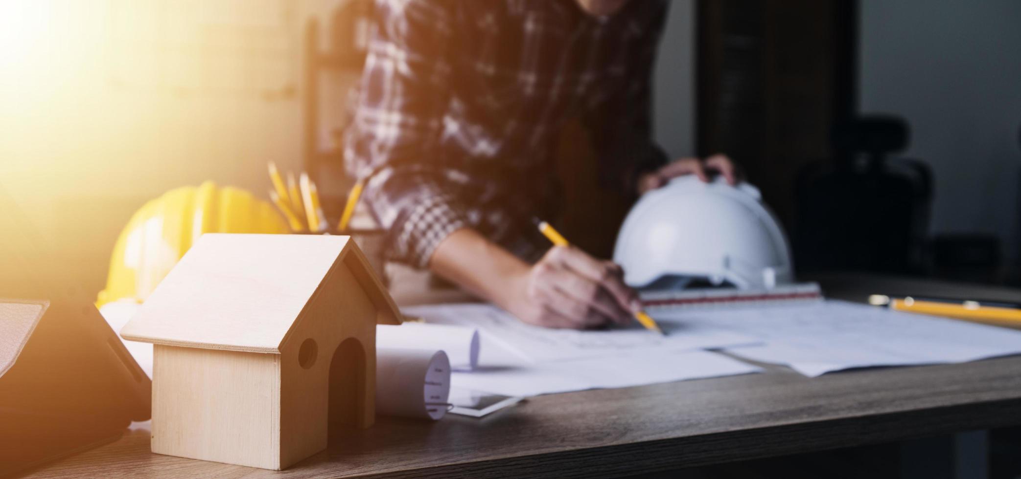 Construction engineer working at blueprint to build large commercial buildings in office. Engineering tools and construction concept. photo