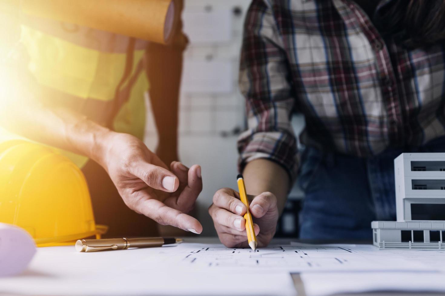Construction engineer working at blueprint to build large commercial buildings in office. Engineering tools and construction concept. photo