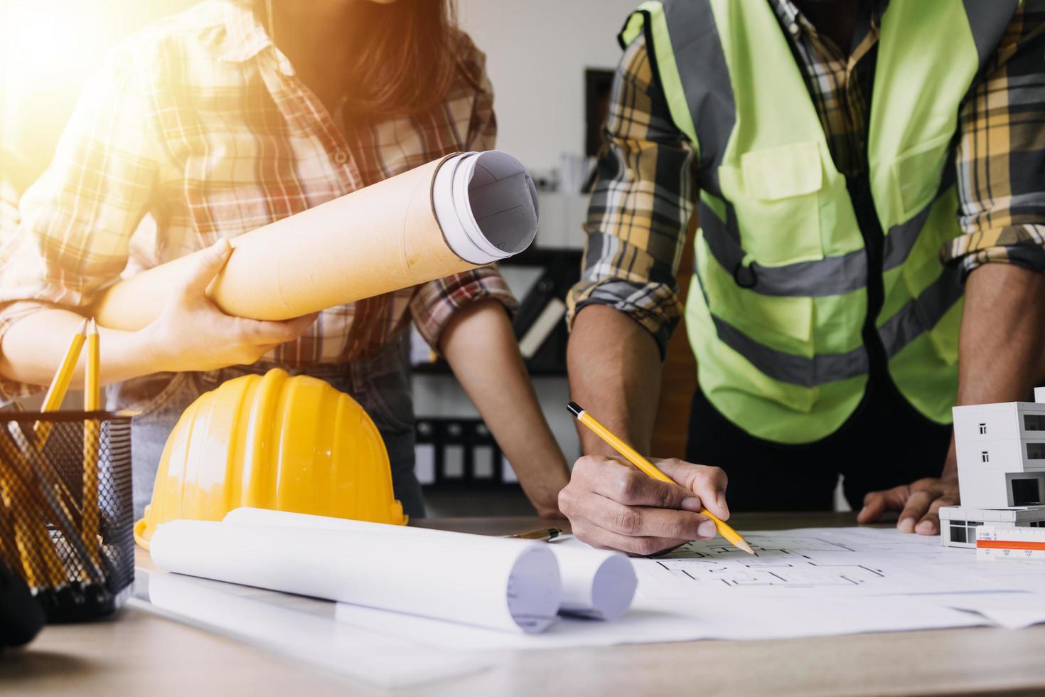 ingeniero de construcción que trabaja en planos para construir grandes edificios comerciales en la oficina. herramientas de ingeniería y concepto de construcción. foto