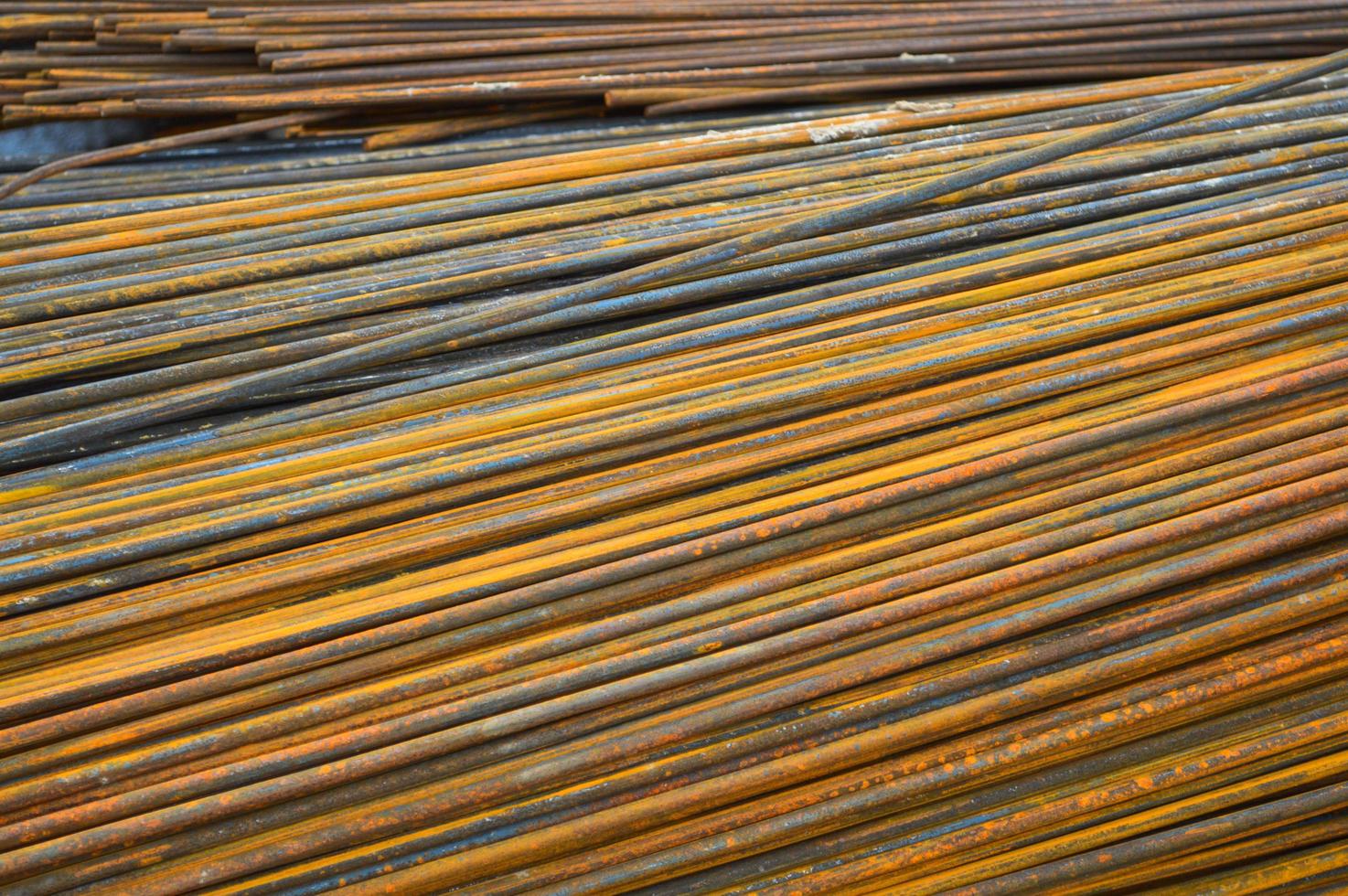 Iron metal rusty yellow bars of industrial building reinforcement from corrugated reinforcement for the construction of buildings made of reinforced concrete. Texture, background photo