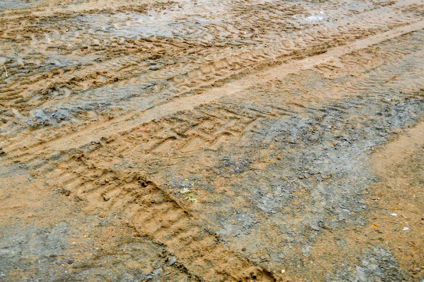 Texture of a dirty bad dirt road dirt road with puddles and clay drying mud with cracks and ruts. Off-road. The background photo