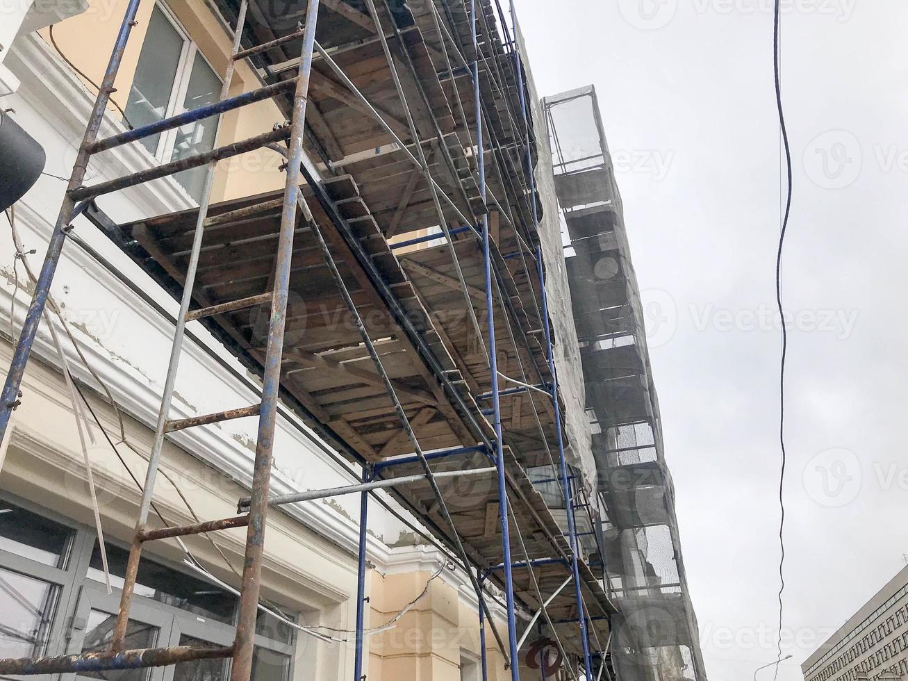 Repair work on the facade of the building with the help of wooden scaffolding, structures, restoration of the old house photo