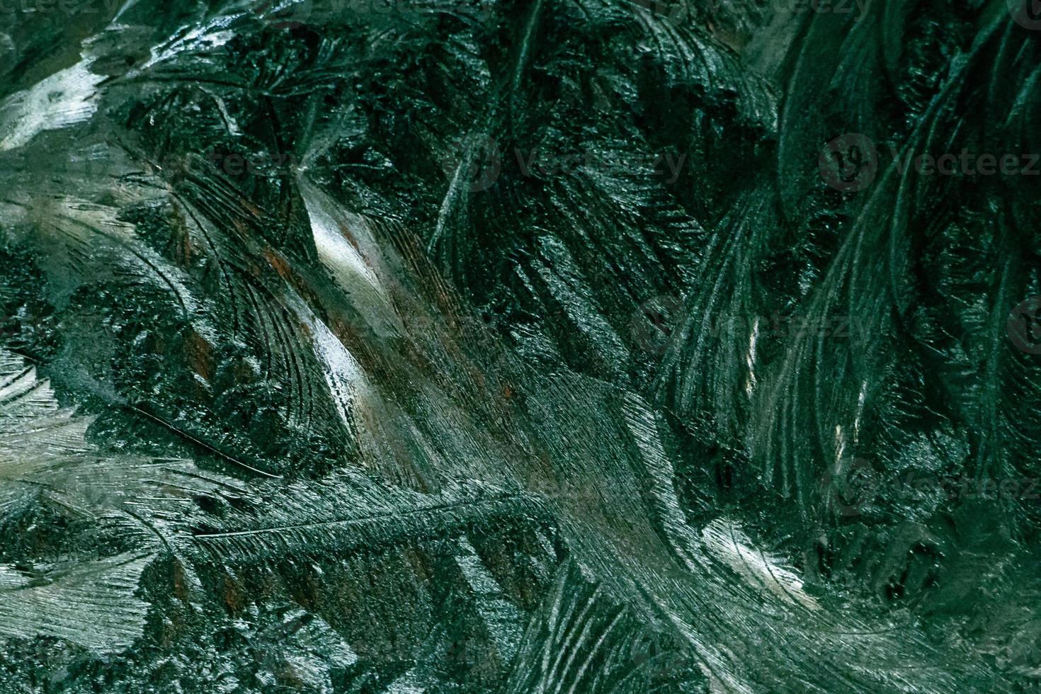 Winter frosty patterns on glass. Shiny ice crystals on window. Christmas mystical background. photo