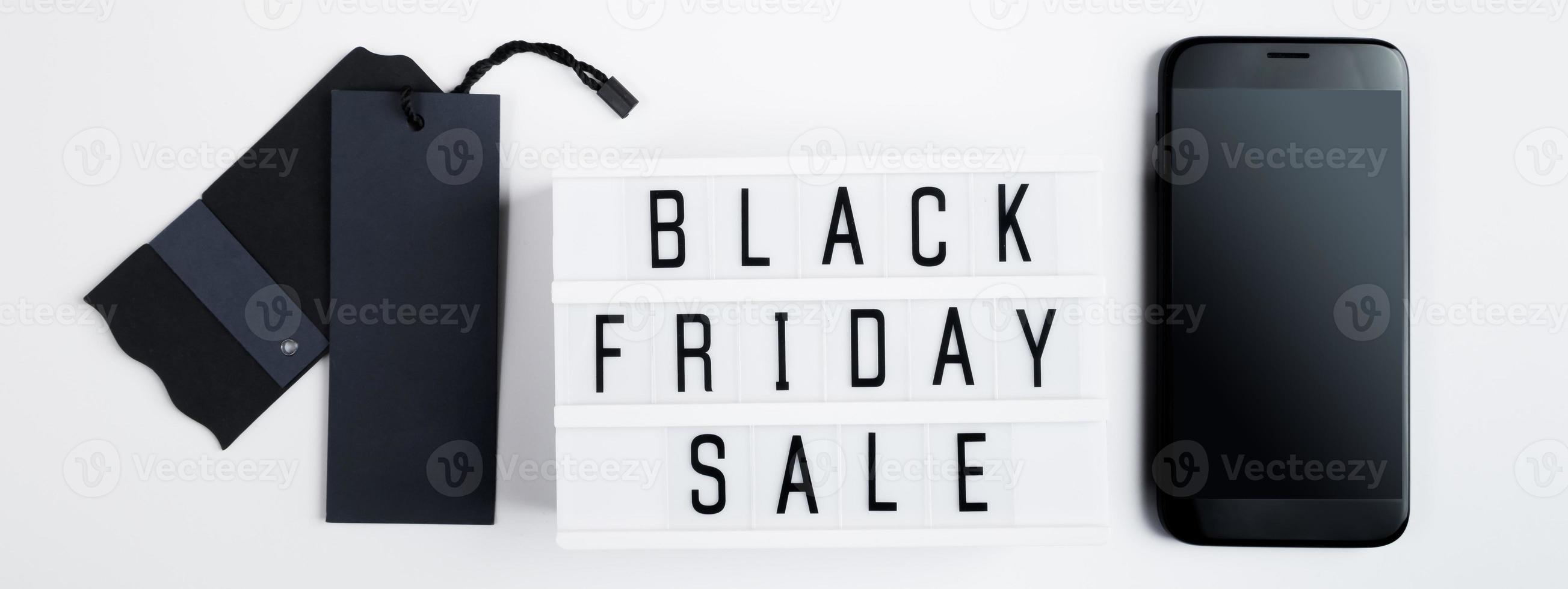 Black Friday sale. Label and mobile phone on white background. Online shopping photo