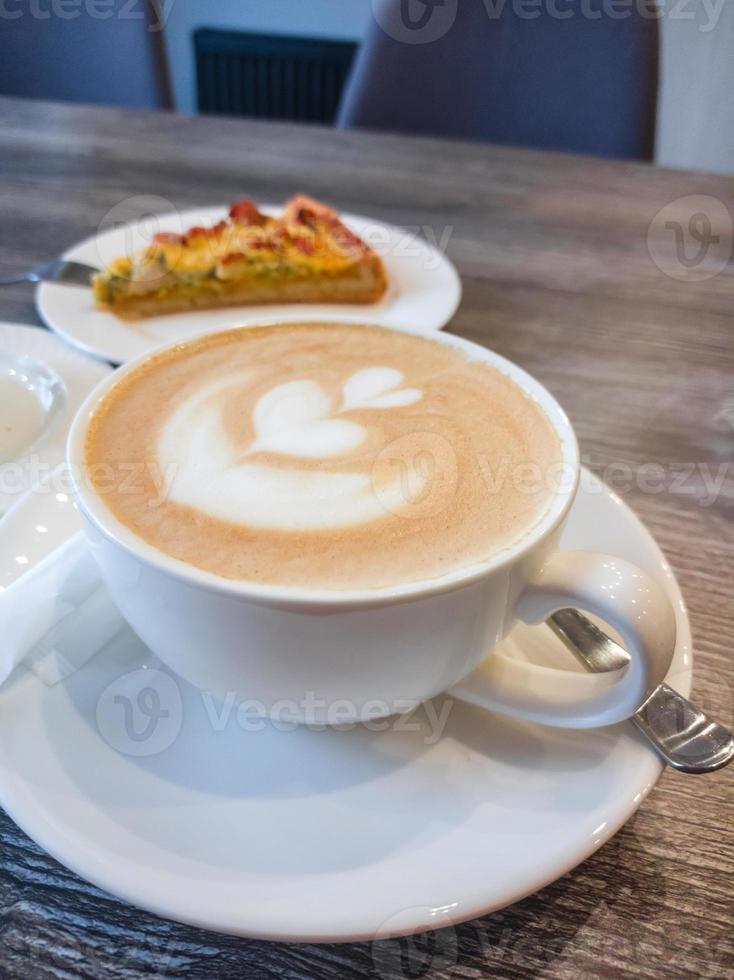Delicious fragrant cappuccino with a pattern on the surface of the foam in a white porcelain cup photo