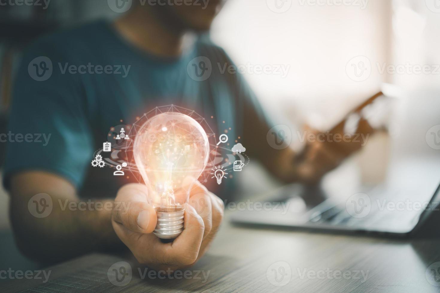Man hand holding light bulb global Internet connection while working on laptop and mobile phone. Business global internet connection application technology and digital marketing financial and banking. photo
