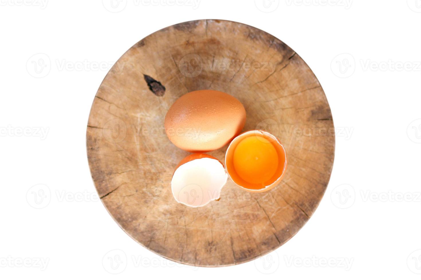 Brown eggs on a wooden chopping board There is a yolk in the egg shell. The brown egg has a drop of water because it is removing from the refrigerator. photo