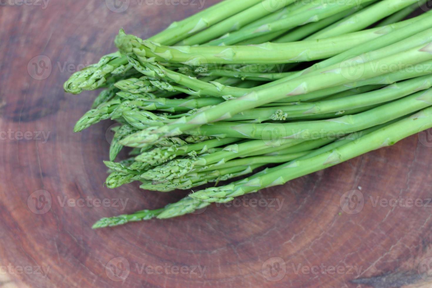 Raw asparagus. Fresh Asparagus on wooden background photo