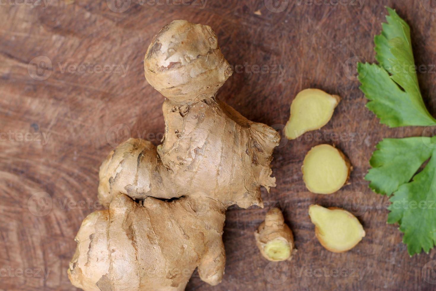 Ginger root sliced on wooden background photo