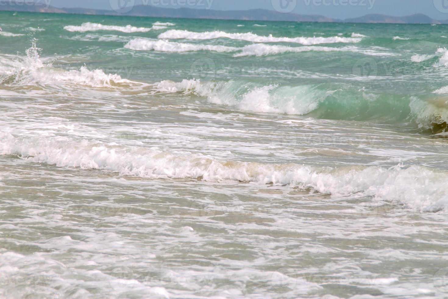 ola suave blanca en playa tropical vacía y mar azul con cielo azul foto