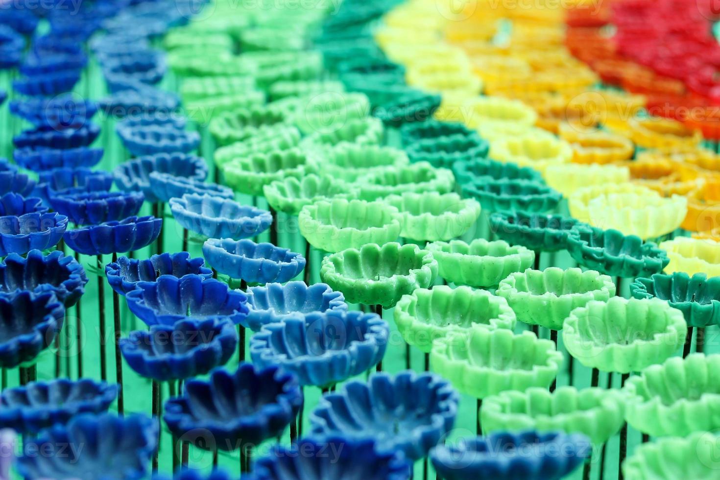 Multicolor Flowers are made from candles as a background. photo