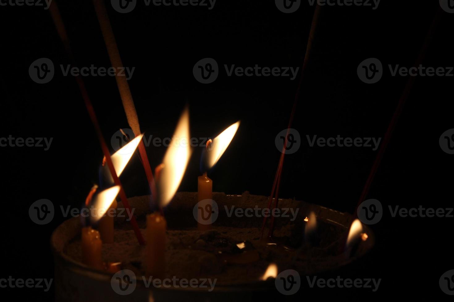 candles burning brightly on black background photo