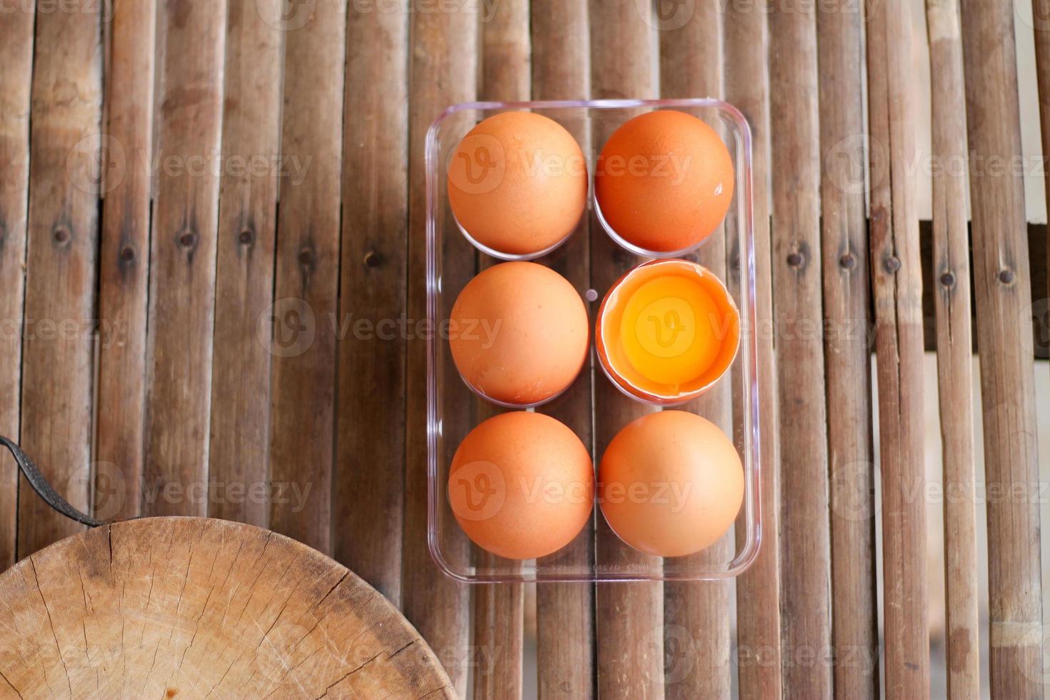 Viewed from above, one of the six broken eggs on a bamboo floor. photo