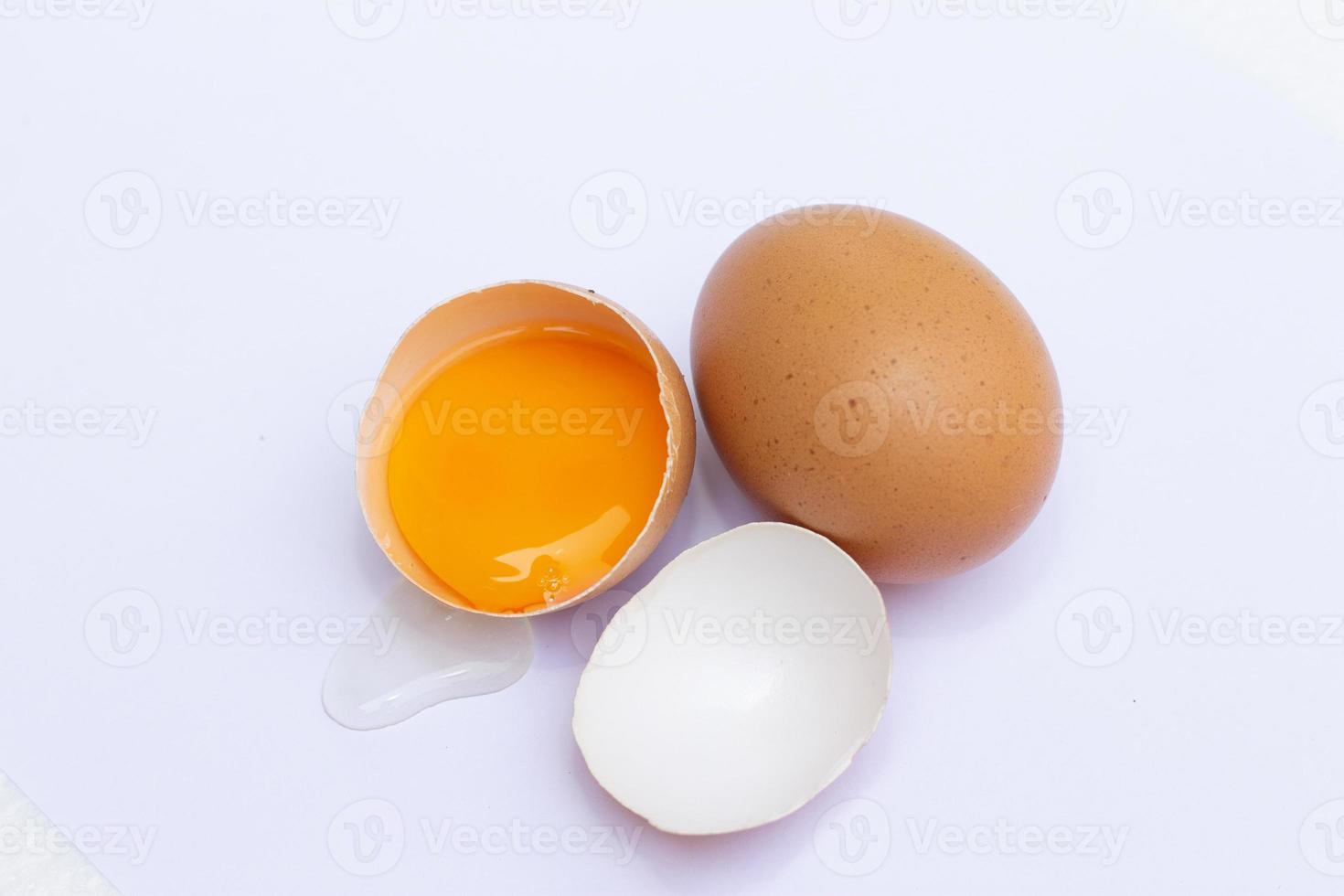 Two brown eggs There was one egg broken in half, with a yolk inside the