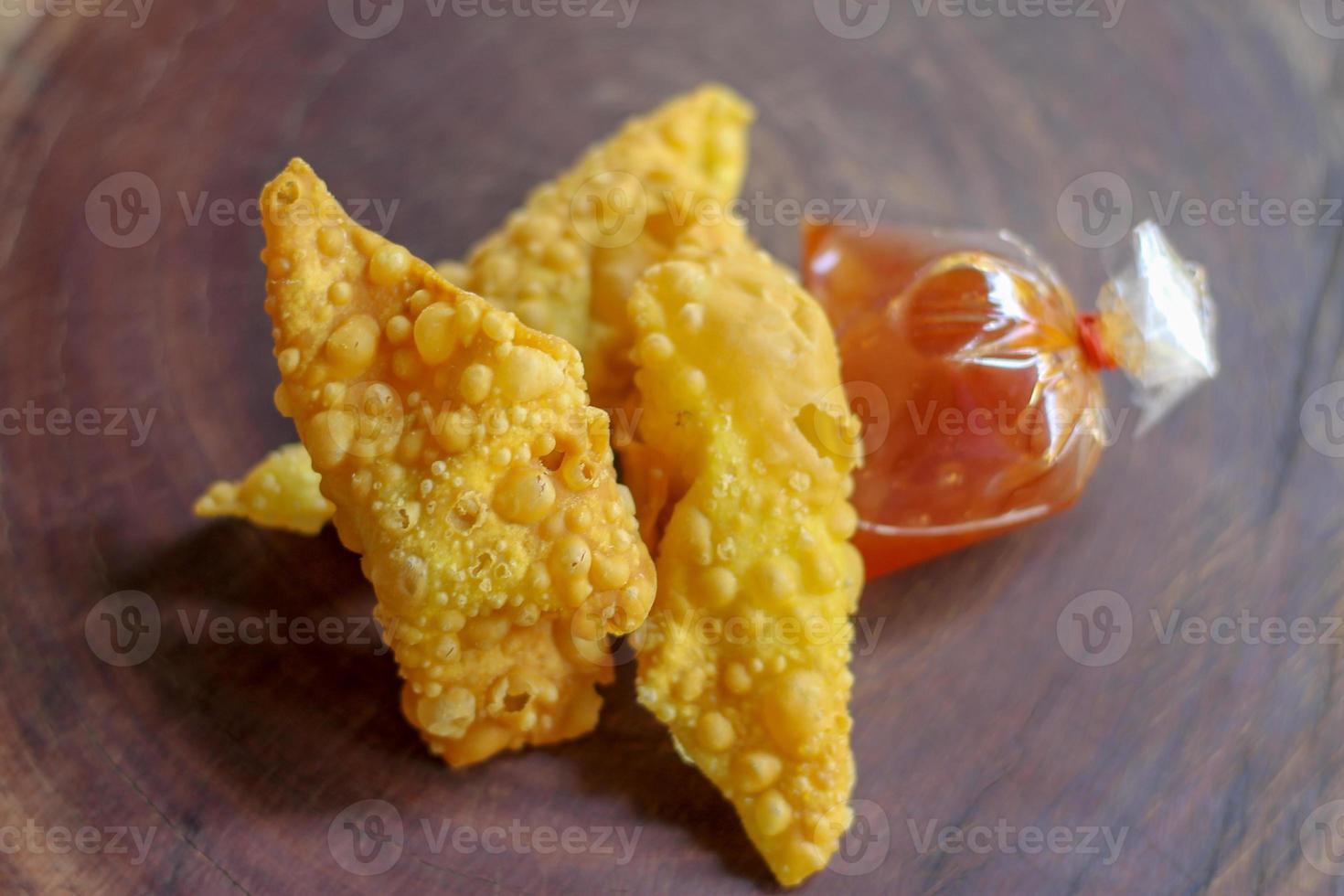 Fried dumplings,chinese food with sauce in plastic bag on wooden table. photo