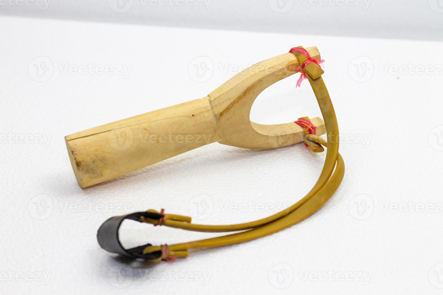 Handmade slingshot catapult. Y-shaped wooden stick with elastic tied between two top parts. Slingshot or Catapult is device for shooting small stones. photo