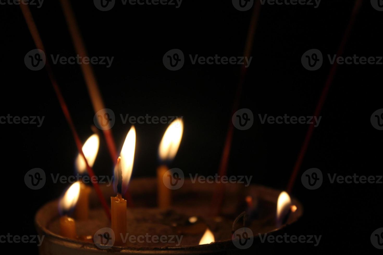 candles burning brightly on black background photo