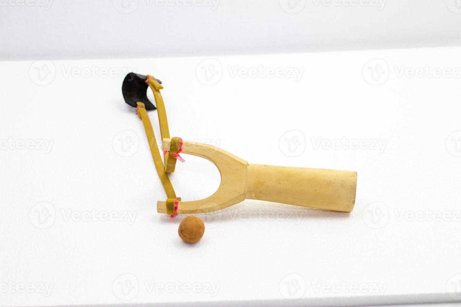 Handmade slingshot catapult. Y-shaped wooden stick with elastic tied between two top parts. Slingshot or Catapult is device for shooting small stones. photo
