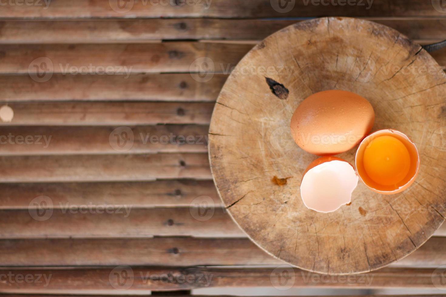 Brown eggs on a wooden chopping board There is a yolk in the egg shell. The brown egg has a drop of water because it is removing from the refrigerator. photo