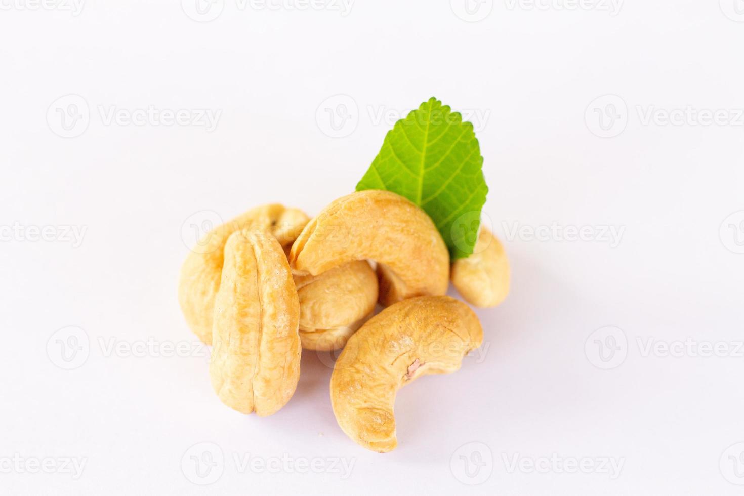 Roasted Cashew nuts with leaf isolated on white background with clipping path and full depth of field. photo