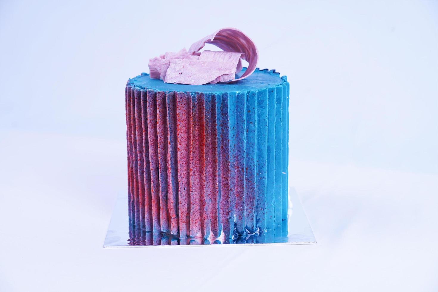Close up luxury cake covered with blue and red coating with white background photo