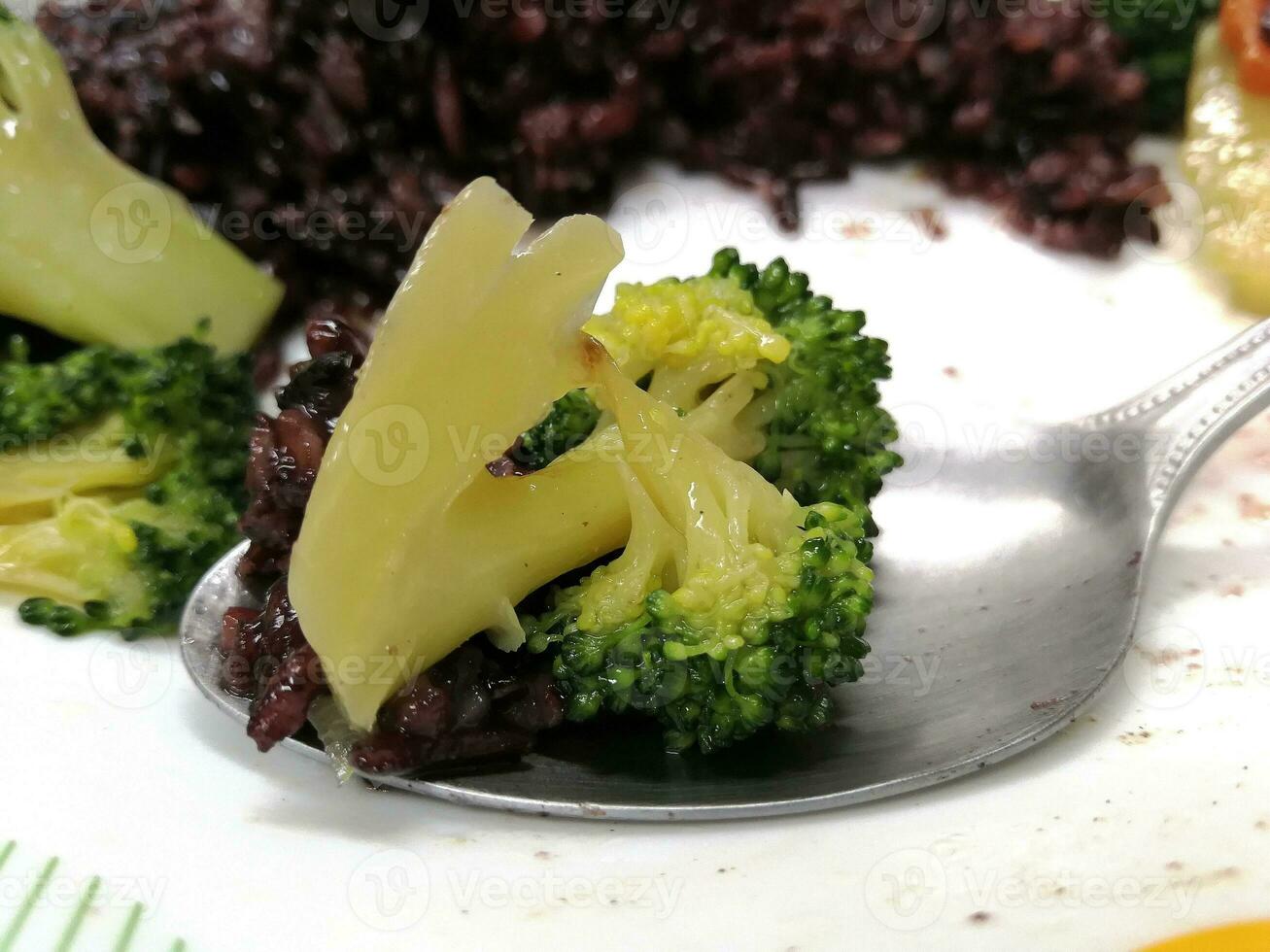 Broccoli and rice are on a spoon. photo