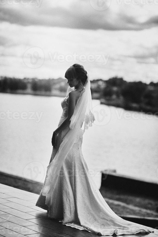 Black and white photo. elegant bride in white dress posing. Bride portrait wedding makeup and hairstyle, fashion bride. wedding day. noise and grain in the photo