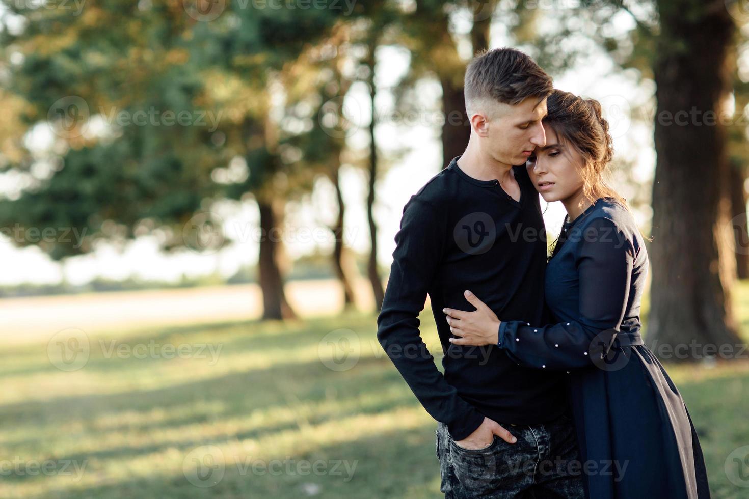 Cheerful young woman and man are hugging outdoor in summer park. Dating and romantic vacation. couple in love gently looking at each other on sunny day. valentines day. photo