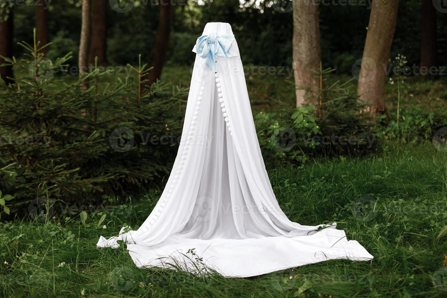 white children's wigwam,tent with a blanket in a green summer sunny garden photo