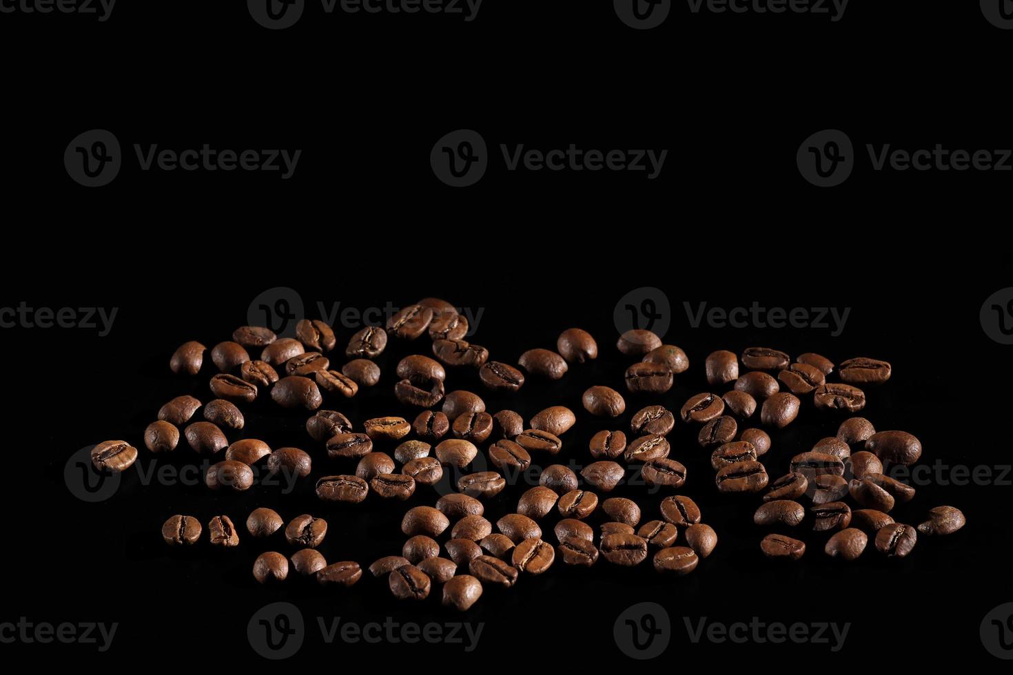 scattered coffee beans. fragrant coffee on the table. coffee is large. coffee on a black background. place for text photo