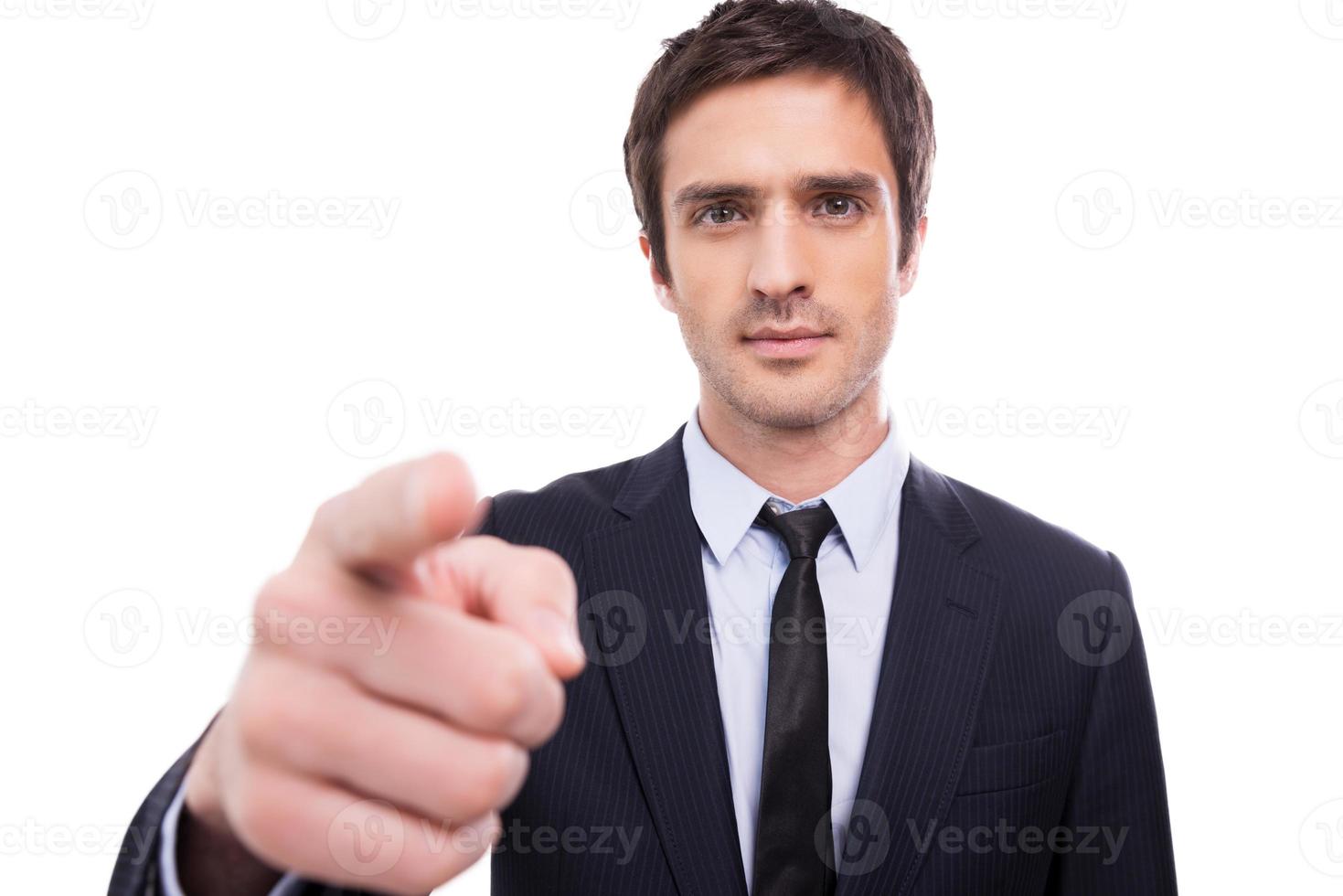 I choose you Serious young man in formalwear pointing you while standing isolated on white background photo