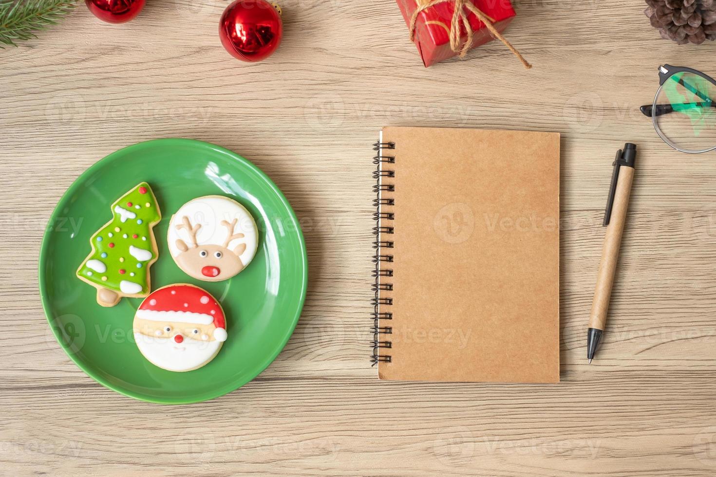 Blank notebook, black, Christmas cookies and pen on wood table, Top view and copy space. Xmas, Happy New Year, Goals, Resolution, To do list, Strategy and Plan concept photo