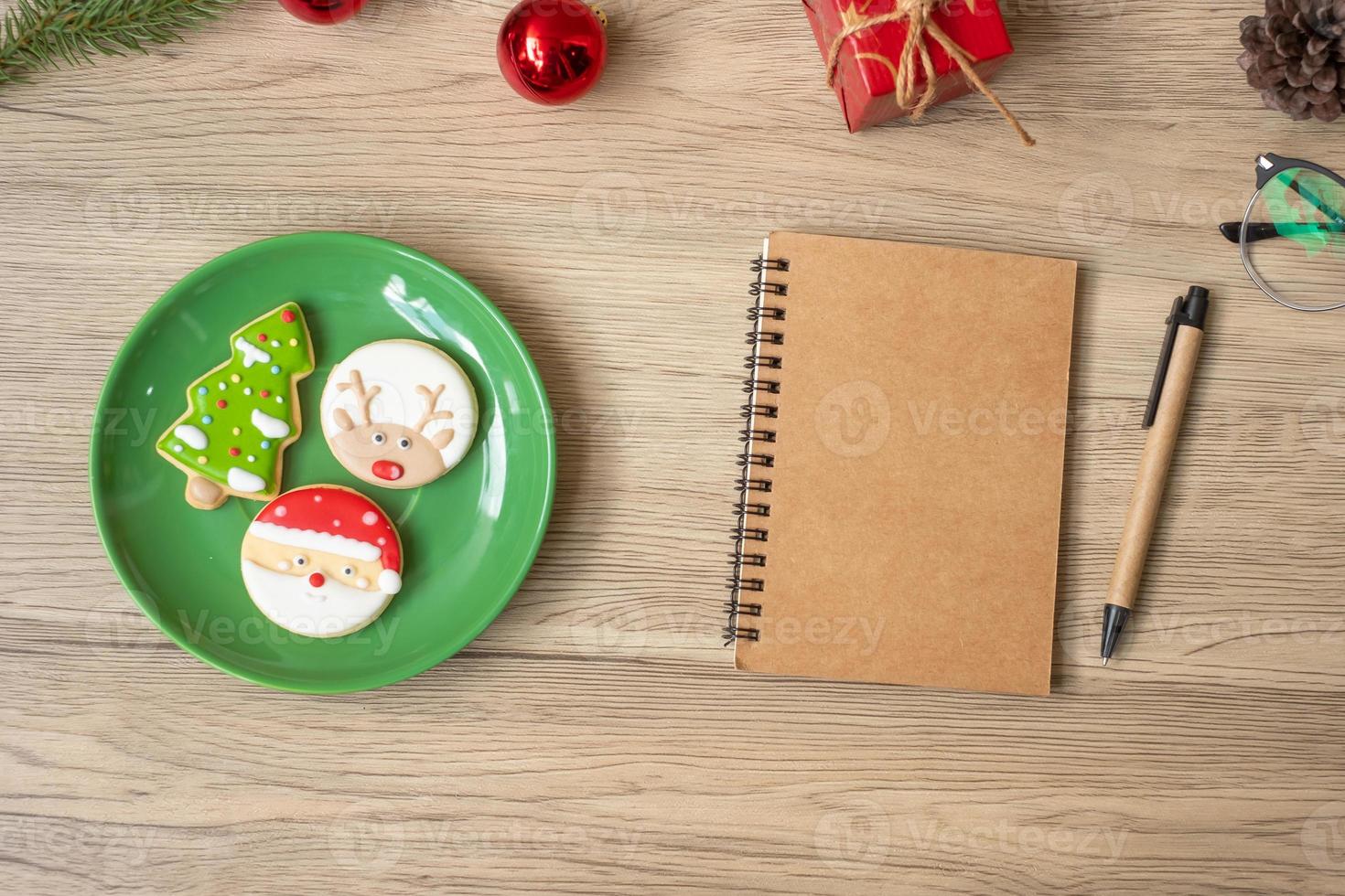 Blank notebook, black, Christmas cookies and pen on wood table, Top view and copy space. Xmas, Happy New Year, Goals, Resolution, To do list, Strategy and Plan concept photo