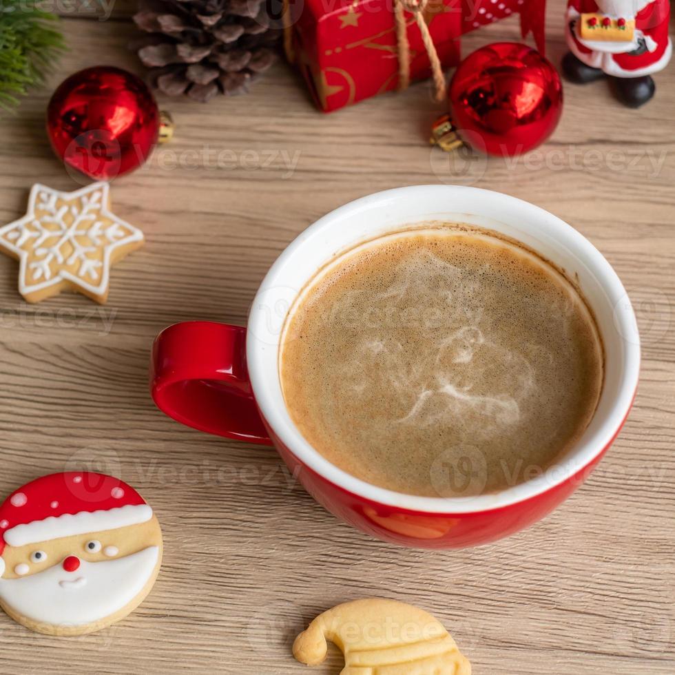 feliz navidad con galletas caseras y taza de café sobre fondo de mesa de madera. concepto de víspera de navidad, fiesta, vacaciones y feliz año nuevo foto